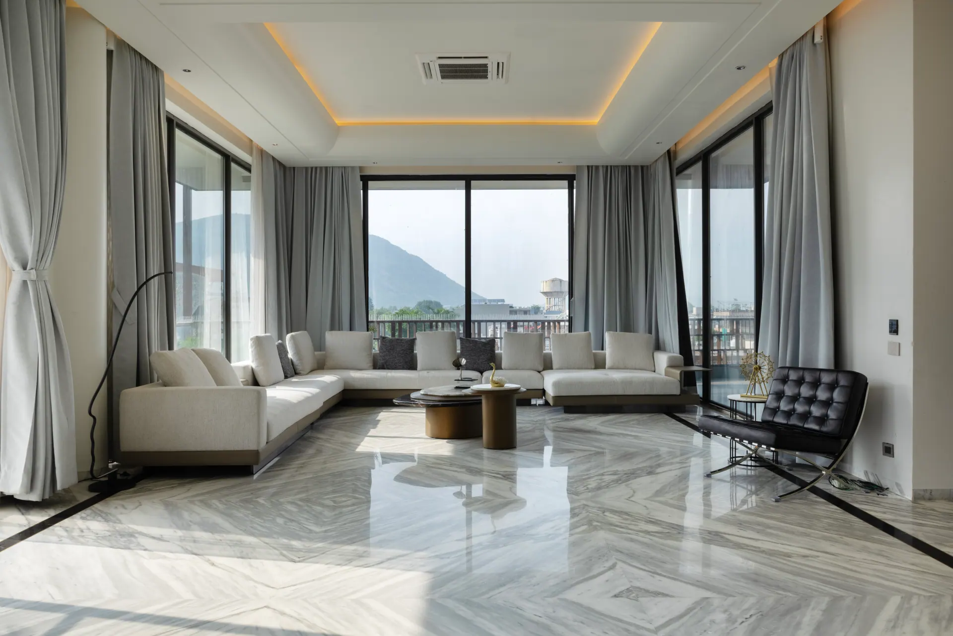 Spacious living room with floor-to-ceiling aluminium windows overlooking the hills